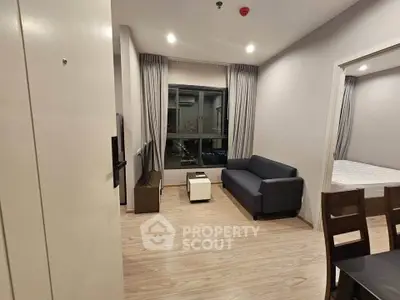 Modern apartment living room with sleek furniture and city view window.