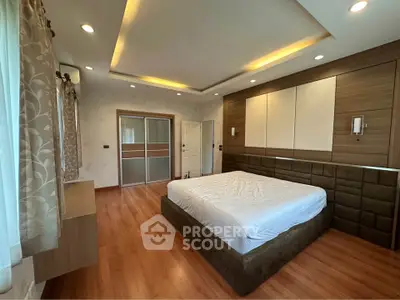Spacious modern bedroom with elegant lighting and wooden flooring