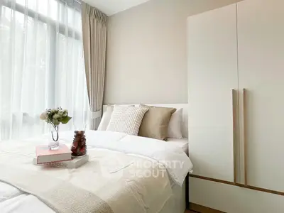 Serene bedroom with plush bedding, elegant neutral tones, and natural light filtering through sheer curtains, creating a peaceful retreat.