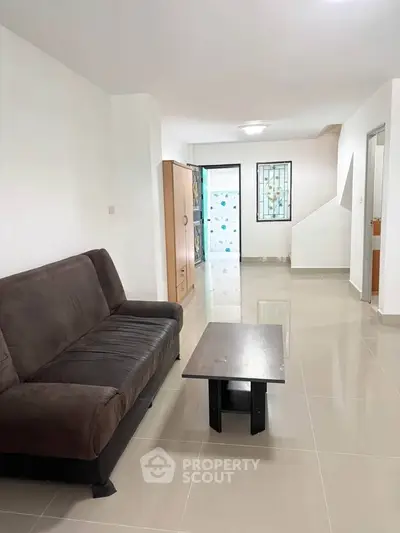 Spacious living room with modern sofa and sleek coffee table in a bright, open layout.