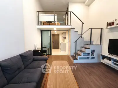 Modern loft apartment with mezzanine, stylish staircase, and cozy living area.