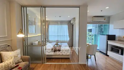 Modern studio apartment with sliding glass doors, cozy bedroom, and stylish kitchen area.