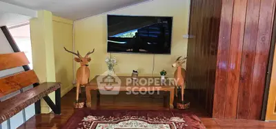 Charming living room with rustic decor and mounted TV, perfect for cozy gatherings.