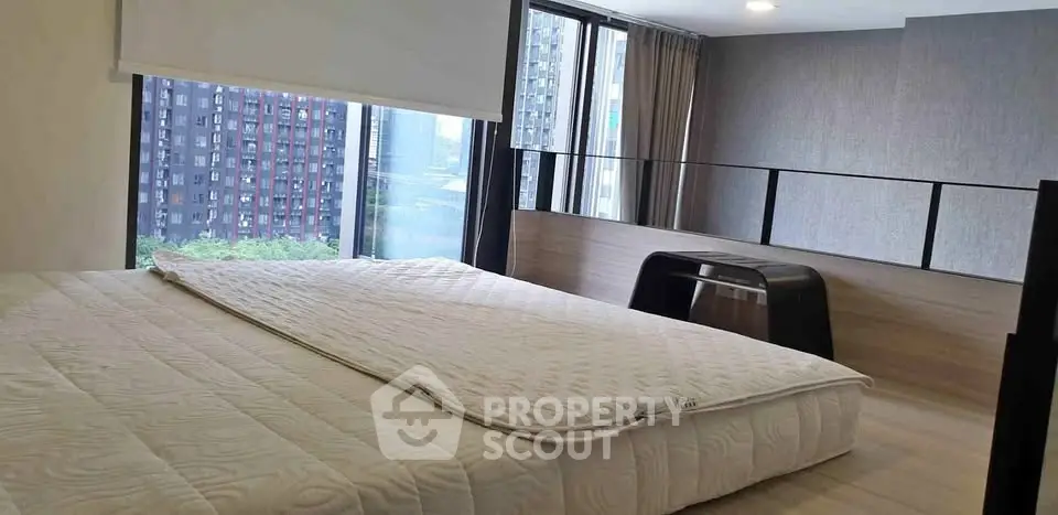 Modern bedroom with large windows and city view in high-rise apartment