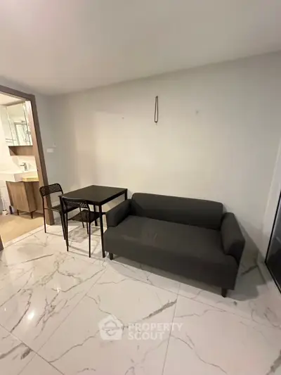 Modern living room with sleek sofa and dining set on glossy tiled floor