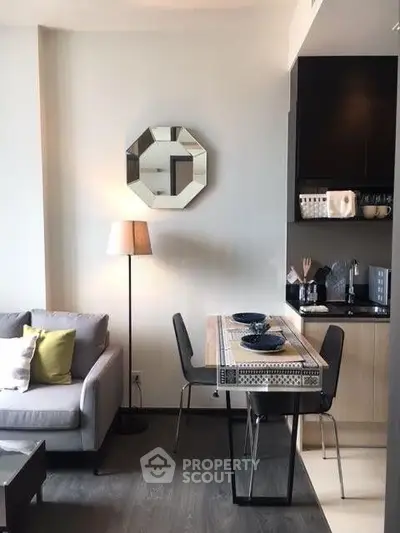 Modern living room with stylish decor and compact dining area in a cozy apartment.