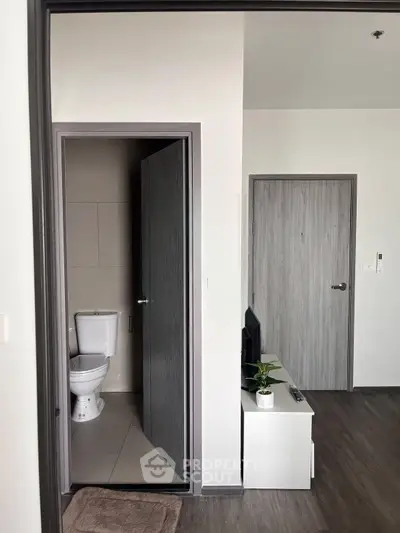 Modern apartment interior with bathroom and living area, featuring sleek design and contemporary finishes.