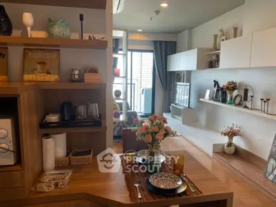 Stylish living room with modern decor and dining setup, featuring open shelving and natural light.