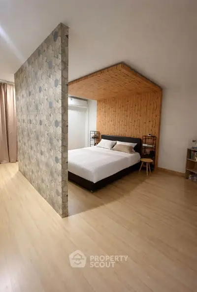 Modern bedroom with unique wooden ceiling and hexagonal accent wall, featuring a cozy bed and stylish decor.