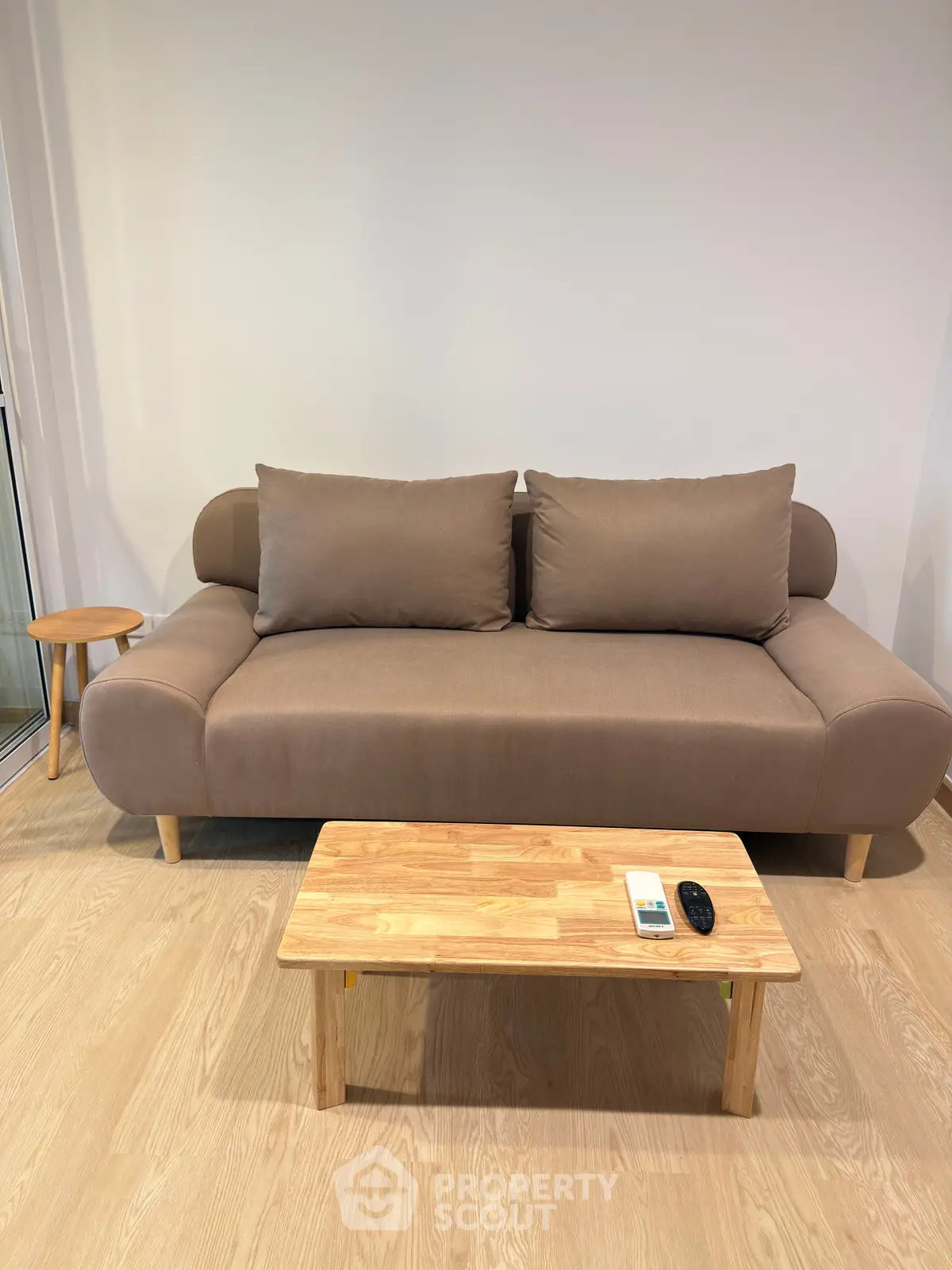 Modern living room with stylish sofa and wooden coffee table, perfect for cozy relaxation.