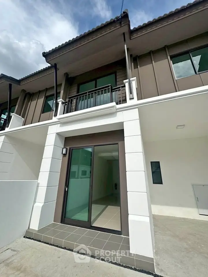 Modern townhouse exterior with sleek design and spacious balcony