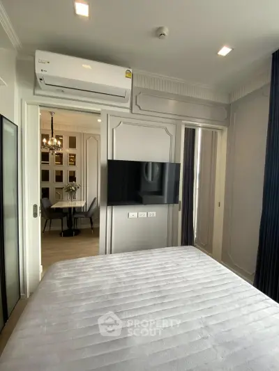 Modern bedroom with air conditioning and wall-mounted TV, adjacent to elegant dining area.