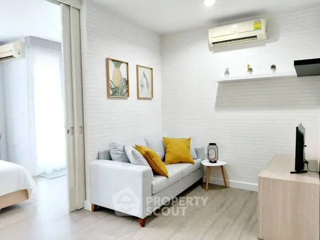Modern living room with cozy sofa, stylish decor, and air conditioning in a bright apartment.