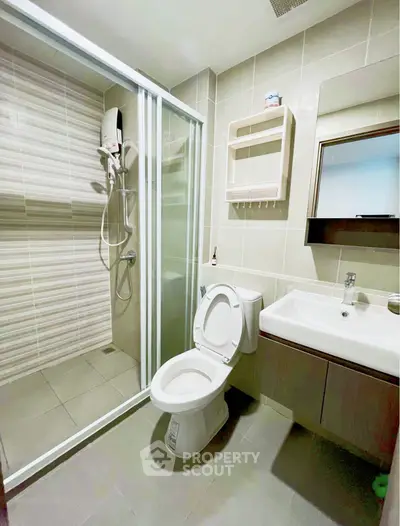 Modern bathroom with glass shower and sleek fixtures in a contemporary apartment.