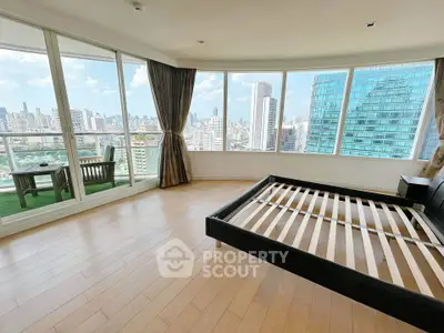 Spacious bedroom with panoramic city views and private balcony access.