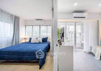 Modern bedroom with blue bedding and balcony view in a stylish apartment