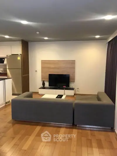 Spacious modern living room with sleek furnishings, hardwood floors, and integrated kitchen, perfect for entertaining and relaxation.