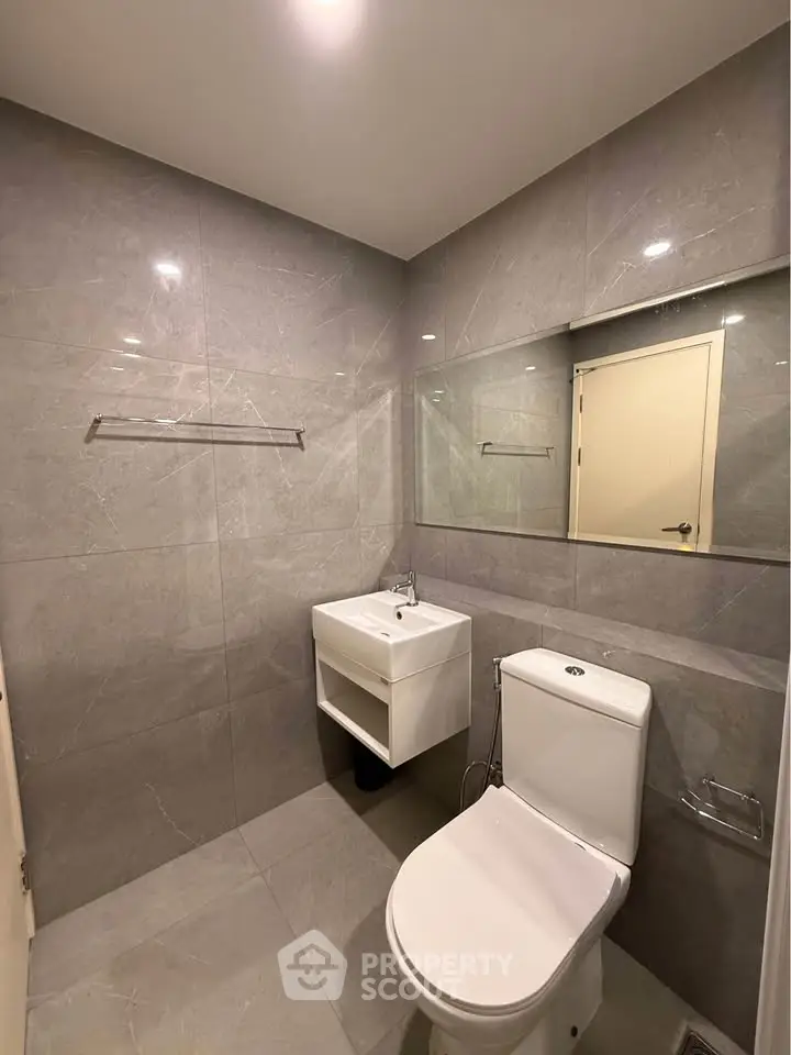 Modern bathroom with sleek gray tiles and compact fixtures