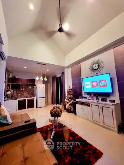 Stylish living room with modern decor, high ceiling, and open kitchen layout, perfect for entertaining.