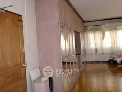 Spacious bedroom with wooden flooring and large mirrored wardrobe