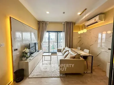 Modern living room with city view, stylish decor, and cozy seating area.