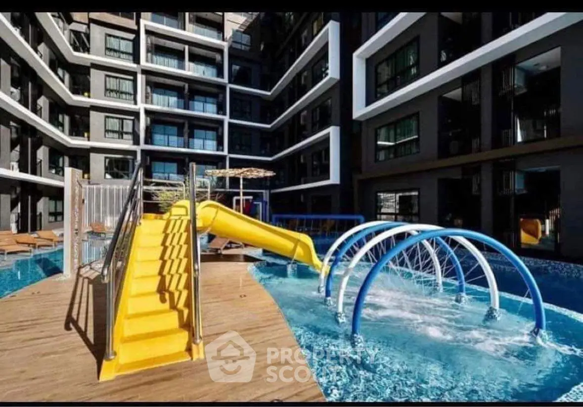 Luxurious apartment complex with modern pool and water slide, perfect for family entertainment.