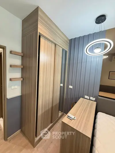 Modern bedroom with sleek wooden wardrobe and stylish lighting fixture
