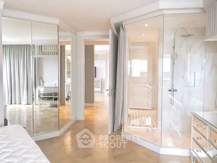 Luxurious bedroom with mirrored closets and elegant ensuite bathroom