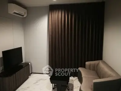 Cozy living room with modern sofa, TV, and air conditioning