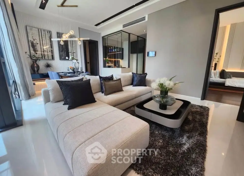 Luxurious modern living room with elegant decor and open layout, featuring plush sofa and stylish dining area.