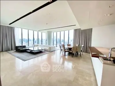 Spacious modern living room with panoramic city views and elegant furnishings.