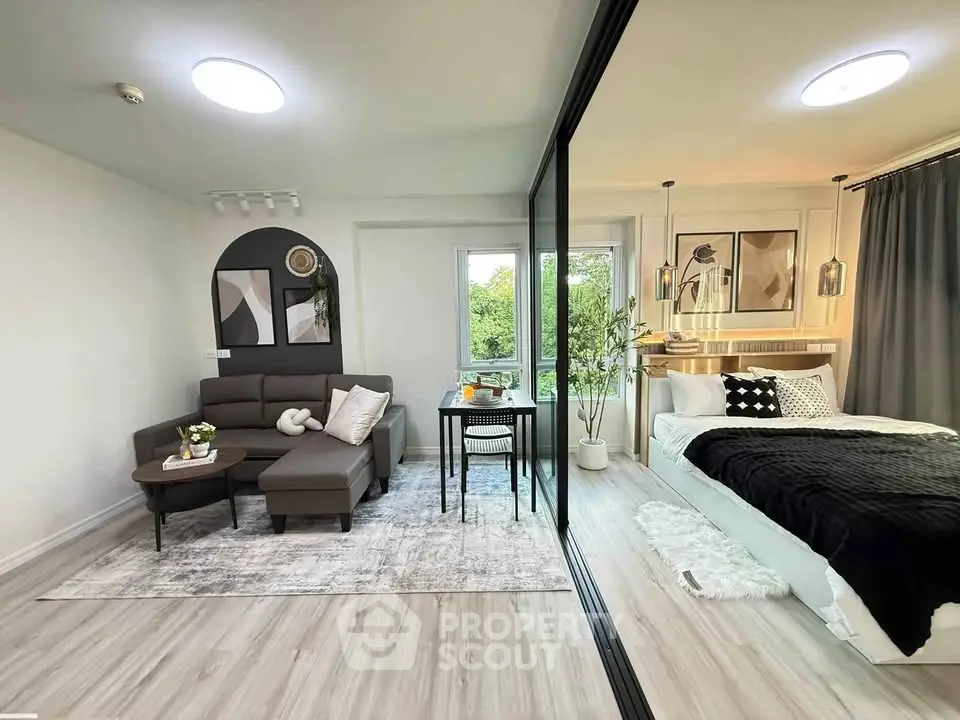 Modern studio apartment with stylish living area and cozy bedroom, featuring elegant decor and natural light.