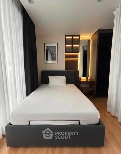 Modern bedroom with sleek design and natural light, featuring a comfortable bed and stylish decor.