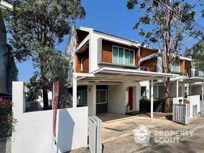 Modern two-story house with carport and contemporary design in a suburban neighborhood.