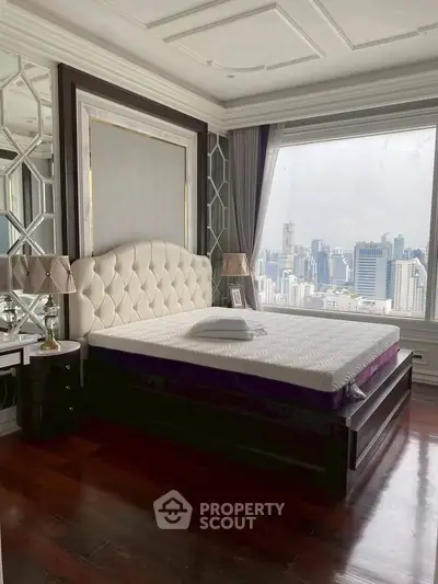 Luxurious bedroom with stunning city view, elegant decor, and plush furnishings in a high-rise apartment.