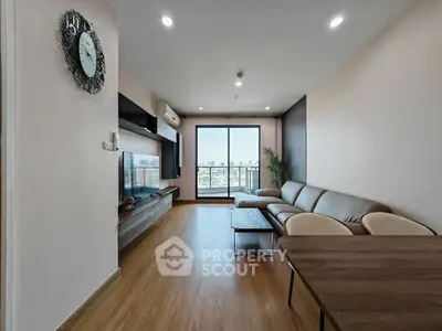 Spacious modern living room with city view, featuring sleek furniture and wooden flooring.
