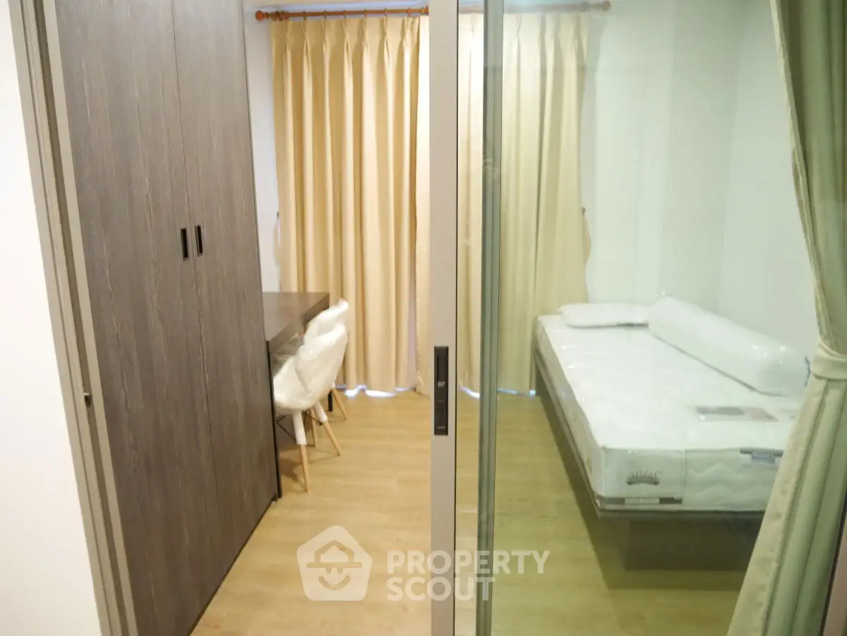 Modern bedroom with glass partition and cozy workspace, featuring a comfortable bed and stylish decor.