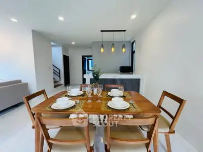 Modern dining area with elegant wooden table and chairs, open layout to living room, stylish lighting.
