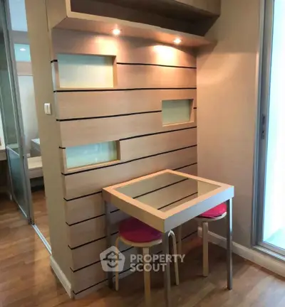 Modern compact study nook with sleek wooden design and glass table in cozy apartment.