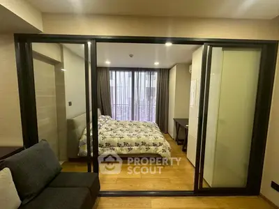 Modern bedroom with sliding glass doors and cozy decor in a stylish apartment.