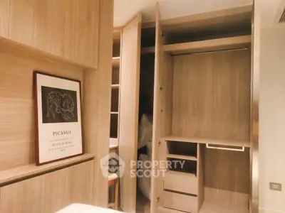 Spacious modern wardrobe with wooden finish and Picasso artwork in stylish bedroom.