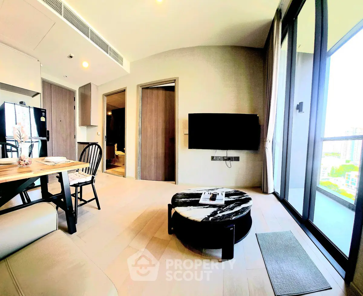 Modern living room with open layout, stylish furniture, and large windows offering city views.