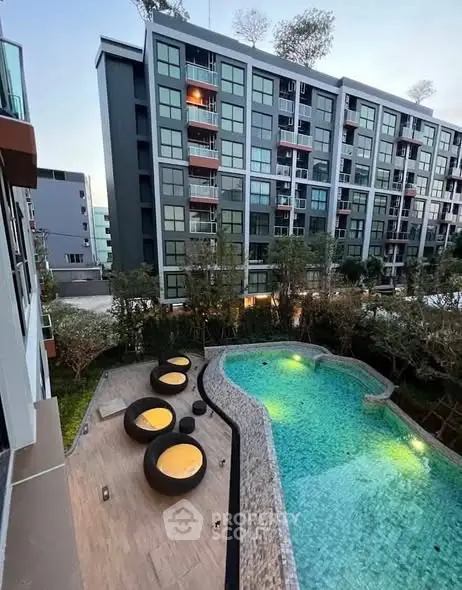 Modern apartment building with stylish pool and outdoor seating area.