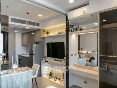 Modern open-plan living room with sleek kitchen and dining area, featuring stylish decor and ample lighting.