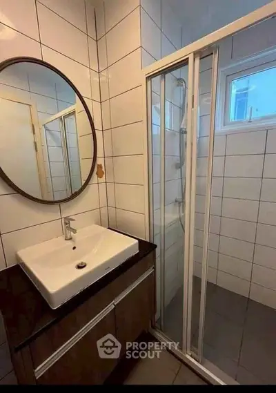 Modern bathroom with sleek shower and stylish vanity in contemporary home.