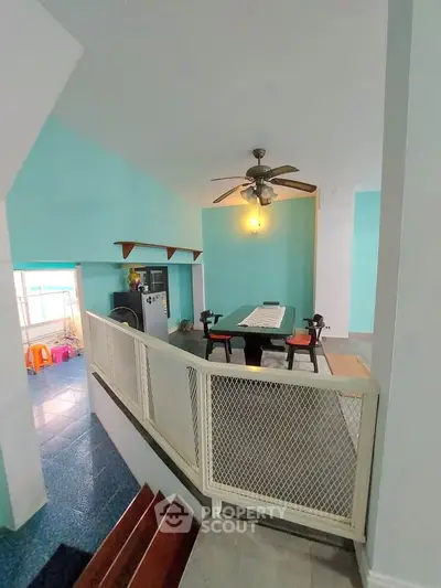 Spacious interior with dining area and ceiling fan, featuring vibrant turquoise walls and modern design.