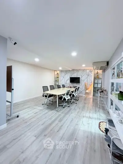 Spacious modern conference room with sleek design and ample seating, perfect for meetings and presentations.