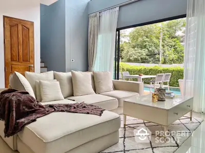 Spacious living room with modern decor and large sliding doors opening to a lush garden view.