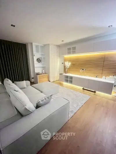 Modern living room with sleek design, featuring a cozy sofa and ambient lighting for a stylish atmosphere.