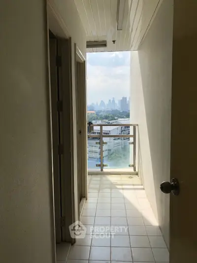 Bright corridor with city view from balcony, perfect for urban living.